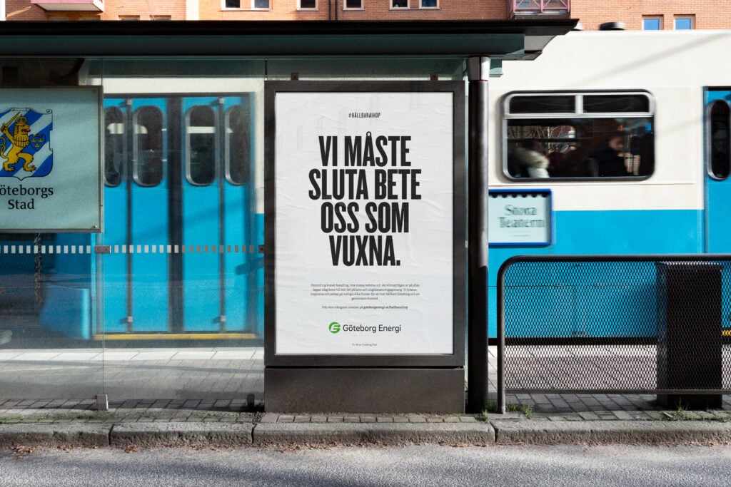 Bus stop ad reads, 'Vi måste sluta bete oss som vuxna' (We must stop acting like adults) with a tram passing behind.