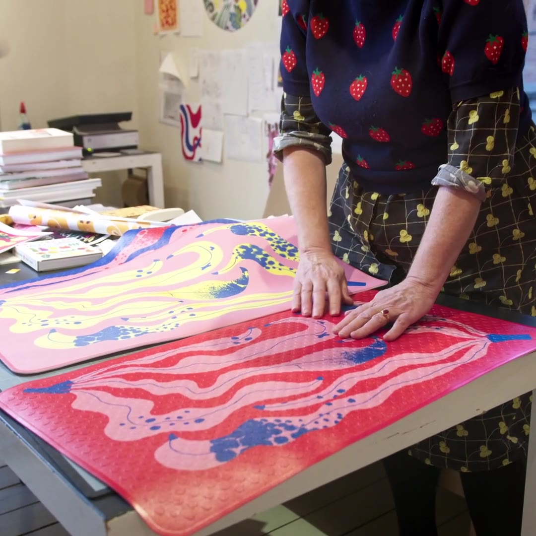 Lotta Kühlhorn smoothing out the finished pink and red mats on her studio work table – campaign short.