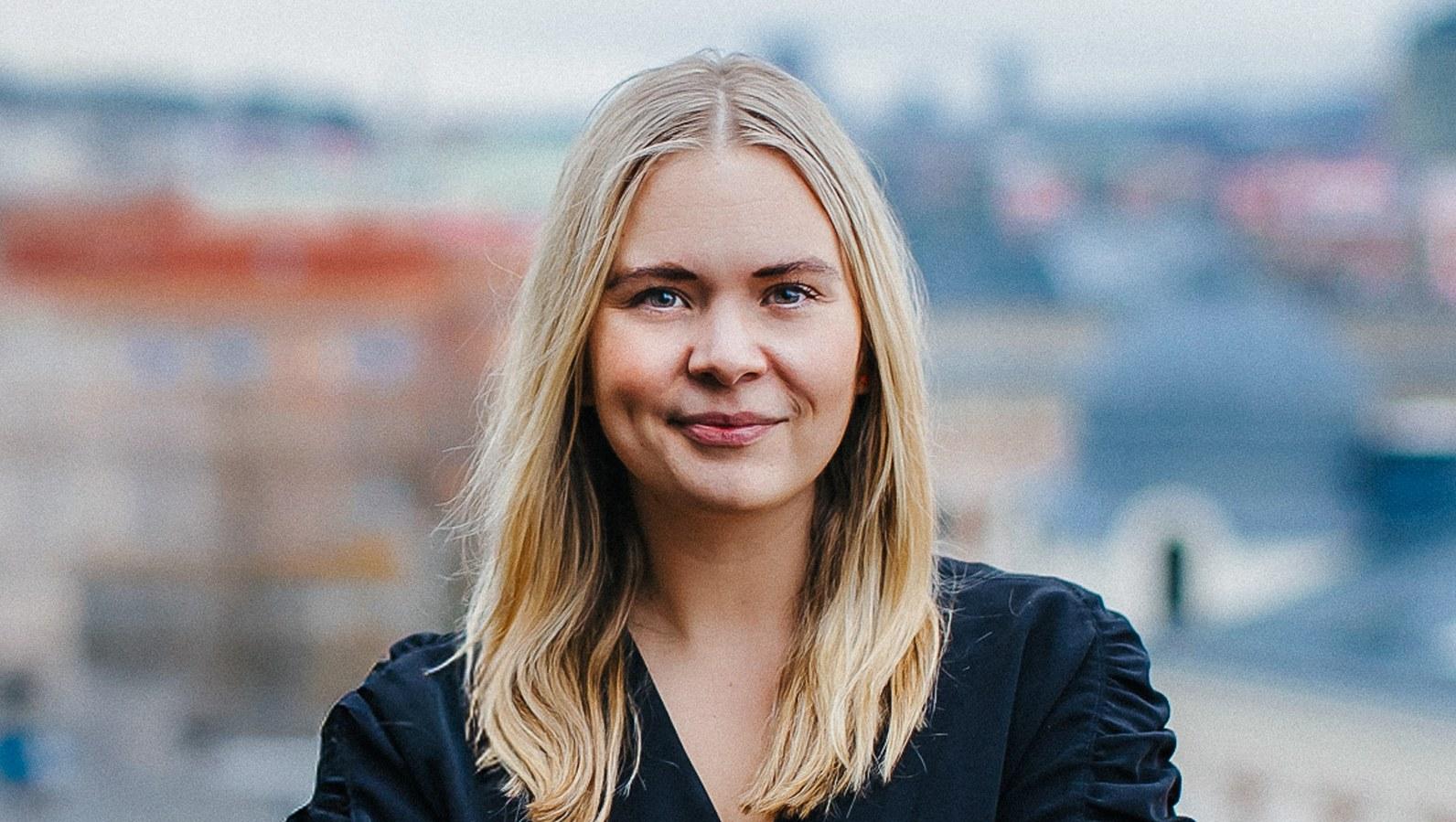 Karin Rödlix, Agency Director at Stendahls, arms crossed on a rooftop with the Gothenburg skyline behind her.