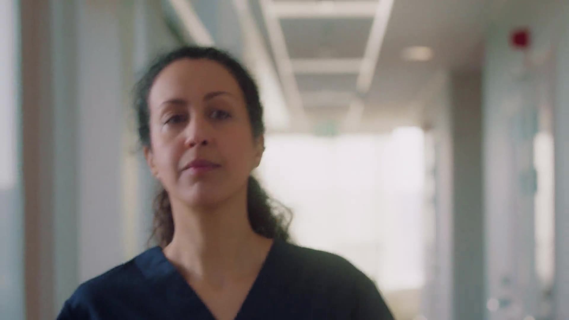 The TENA SmartCare brand film – a caregiver in scrubs walking a bright nursing-home corridor.